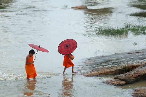 two little monk crosses a small river between their school to village thumbnail