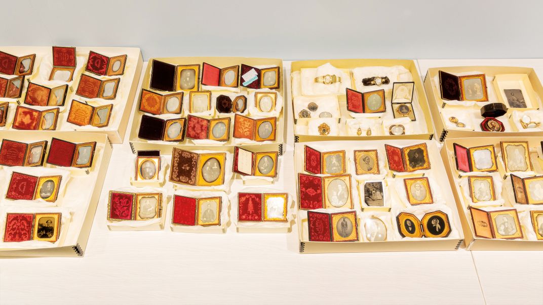 vintage photographs in cases are displayed on a table
