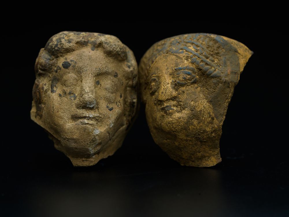 two stone fragments of faces