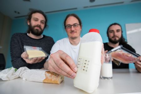 Jonathan Coleman (center) and team show off a printed electronic label.