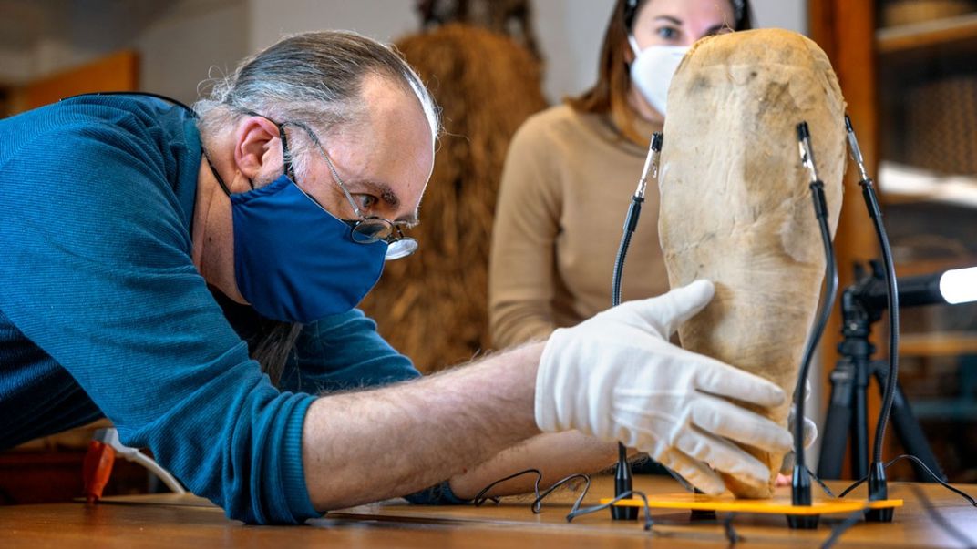 Frederic Gleach, curator of Cornell's anthropology aollections, positions the mummy bird.