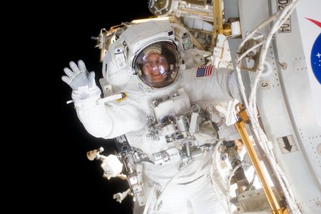 During a spacewalk on mission STS-131, astronaut and author Clay Anderson, hanging from the space station, waved to his shuttle Discovery crewmates.