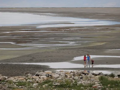 Park visitors walk along a section of the Great Salt Lake that used to be underwater at the Great Salt Lake State Park near Magna, Utah.&nbsp;
