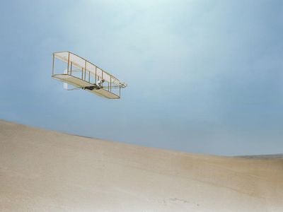 1902: Wilbur Wright gliding down the steep slope of Big Kill Devil Hill.