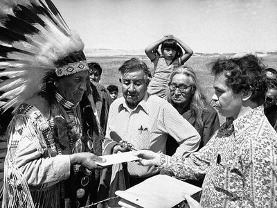 Hank Adams carries a letter from the White House to Chief Frank Fools Crow (Oglala Lakota) during the siege of Wounded Knee. Pine Ridge Reservation, South Dakota, 1973. (Hank Adams Collection)