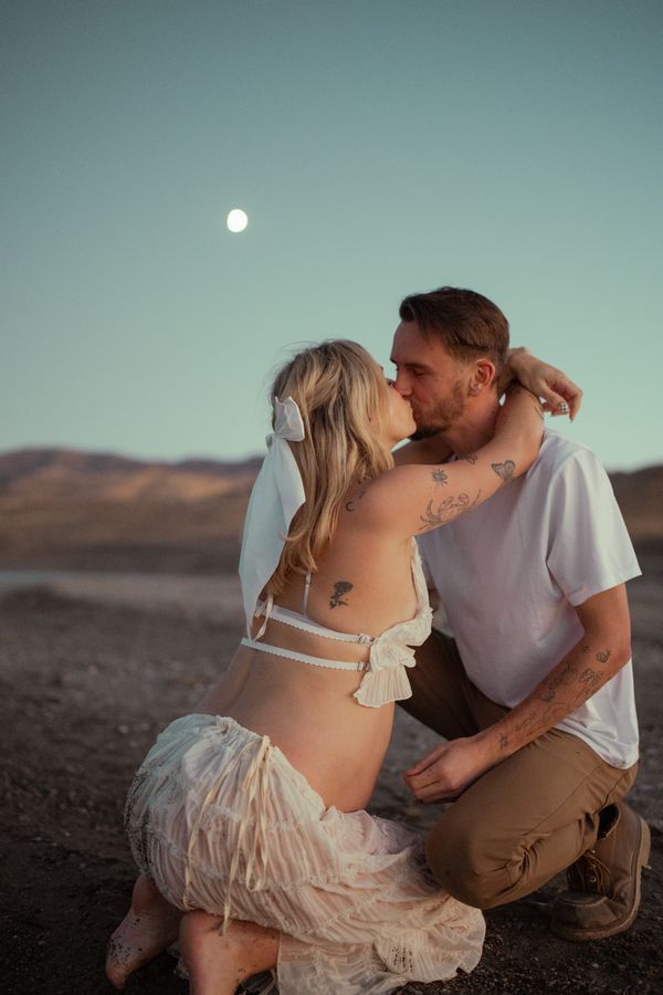 Expectant mother to be and father share a intimate moment under the waxing moon. thumbnail