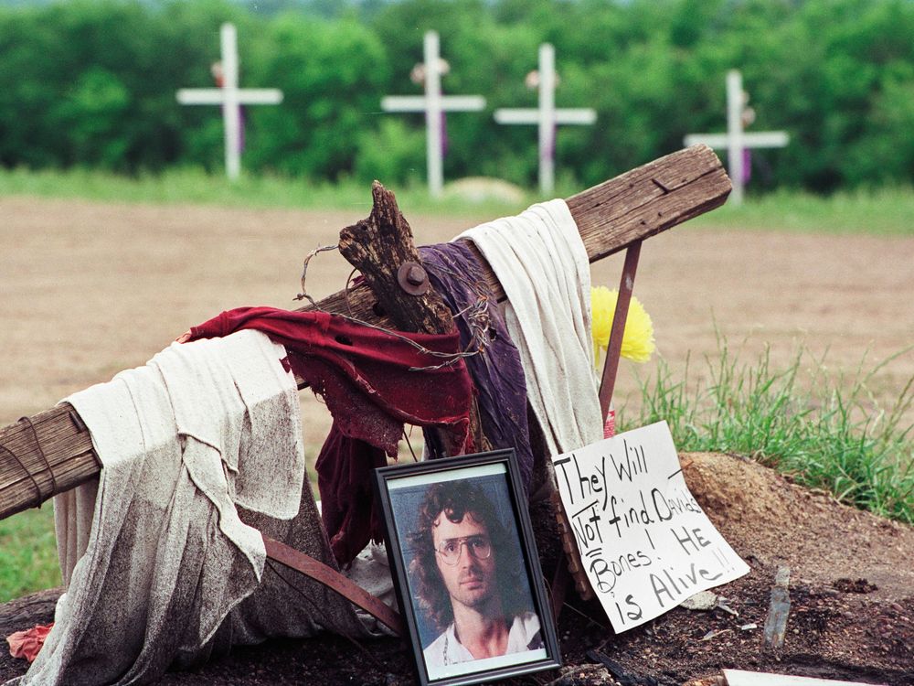 A photo of David Koresh rests beside a wooden cross
