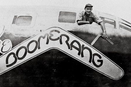 Carl Schahrer, commander of the B-29 Boomerang, shows off the talisman, on which his crew carved their missions.