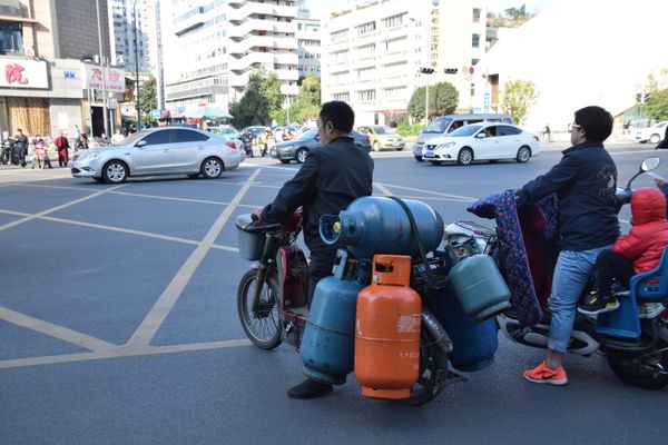 Man on scooter Carrying Propane Gas Tanks thumbnail