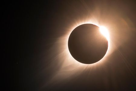 As the 2017 North American total solar eclipse comes to an end, the famous "diamond ring" becomes visible. The sun's corona is also visible, with the star Regulus to the left.
