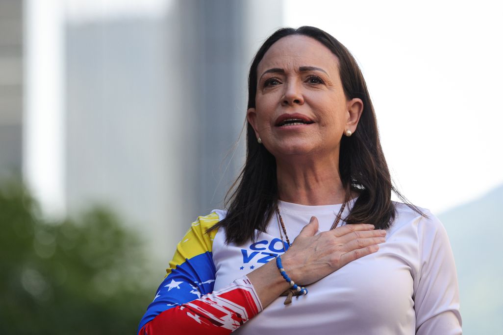 Woman with dark hair with her hand across her heart