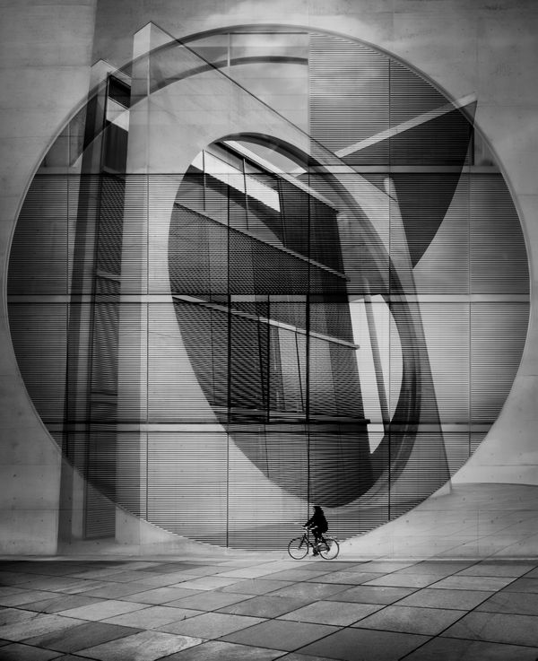 Going in Circles:  A cyclist riding in front of the remarkable Marie-Elisabeth-Lüders-Haus in the Bundestag in Berlin thumbnail