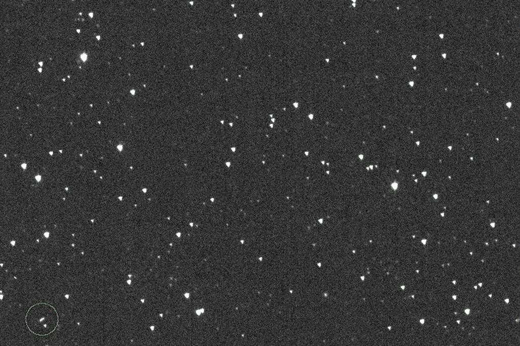 gif of an asteroid, appearing as a point of light flying across a backdrop of stars