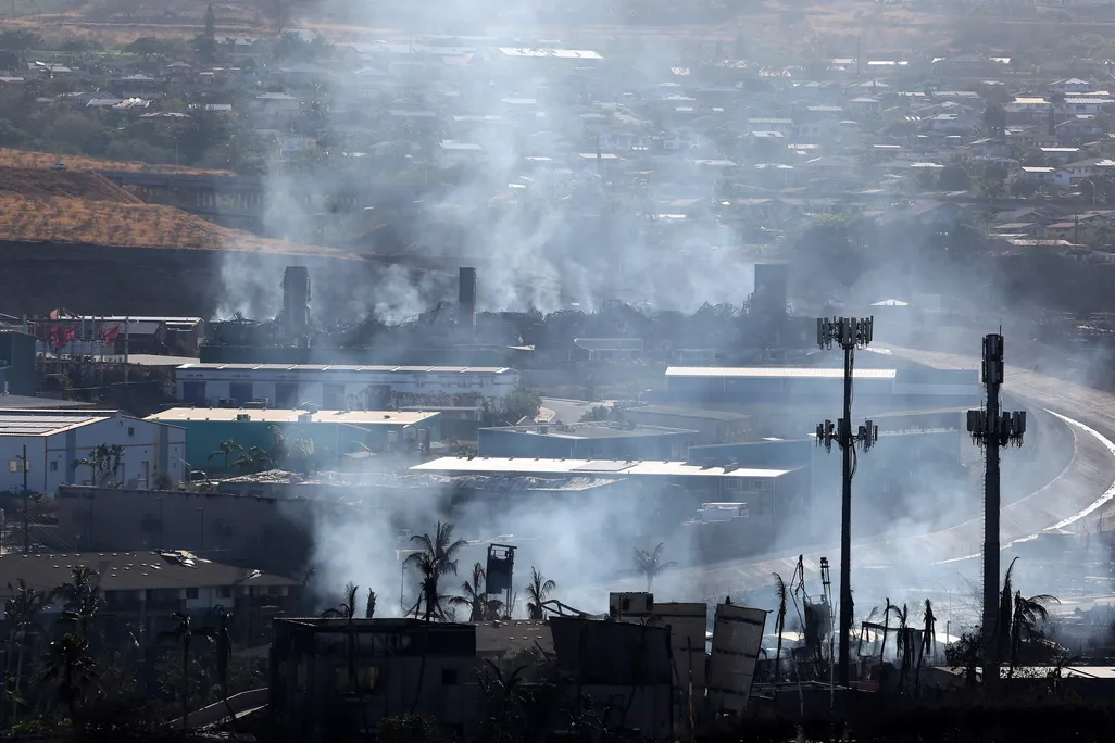 An aerial view of smoke rising from buildings burning from wildfires.