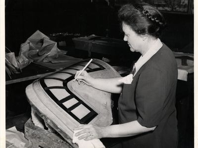 A woman marks a bombardier enclosure for a B-24 Liberator bomber at the Ford Willow Run plant.