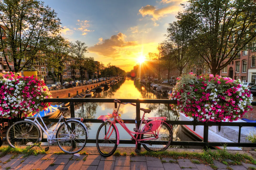 Bicycles on a canal bridge at sunset, Amsterdam. Credit: AMA Waterways