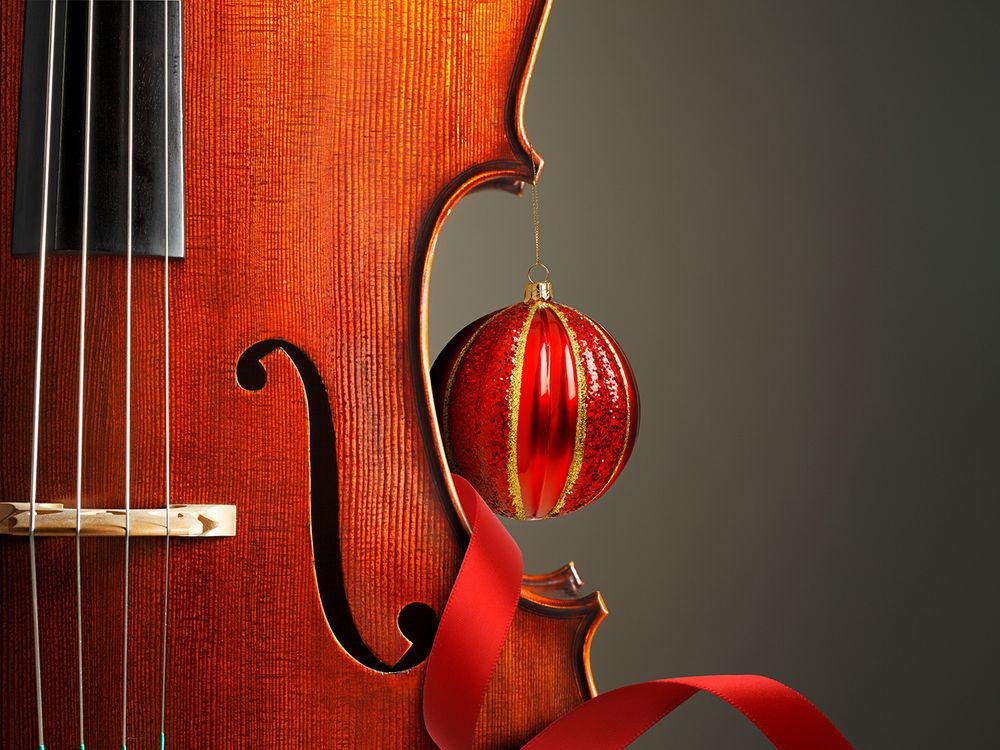A portion of a violin is shown accented with red ribbon and an ornament