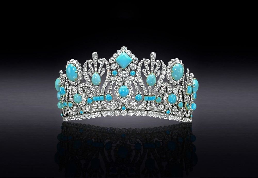 Turquoise and diamond encrusted diadem on a black background that lightens to gray in the center.