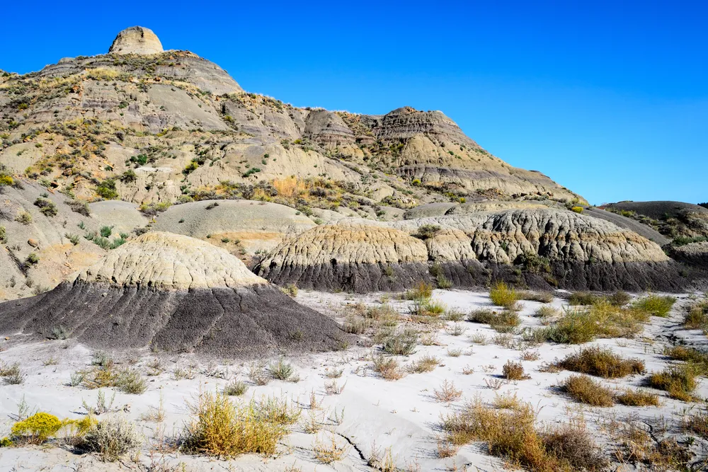 sandy terrain and some mountains with sparse patches of grasses