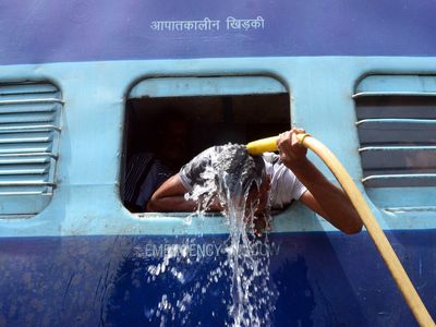 A man cools off using a water pipe at a train station in Allahabad, India. 