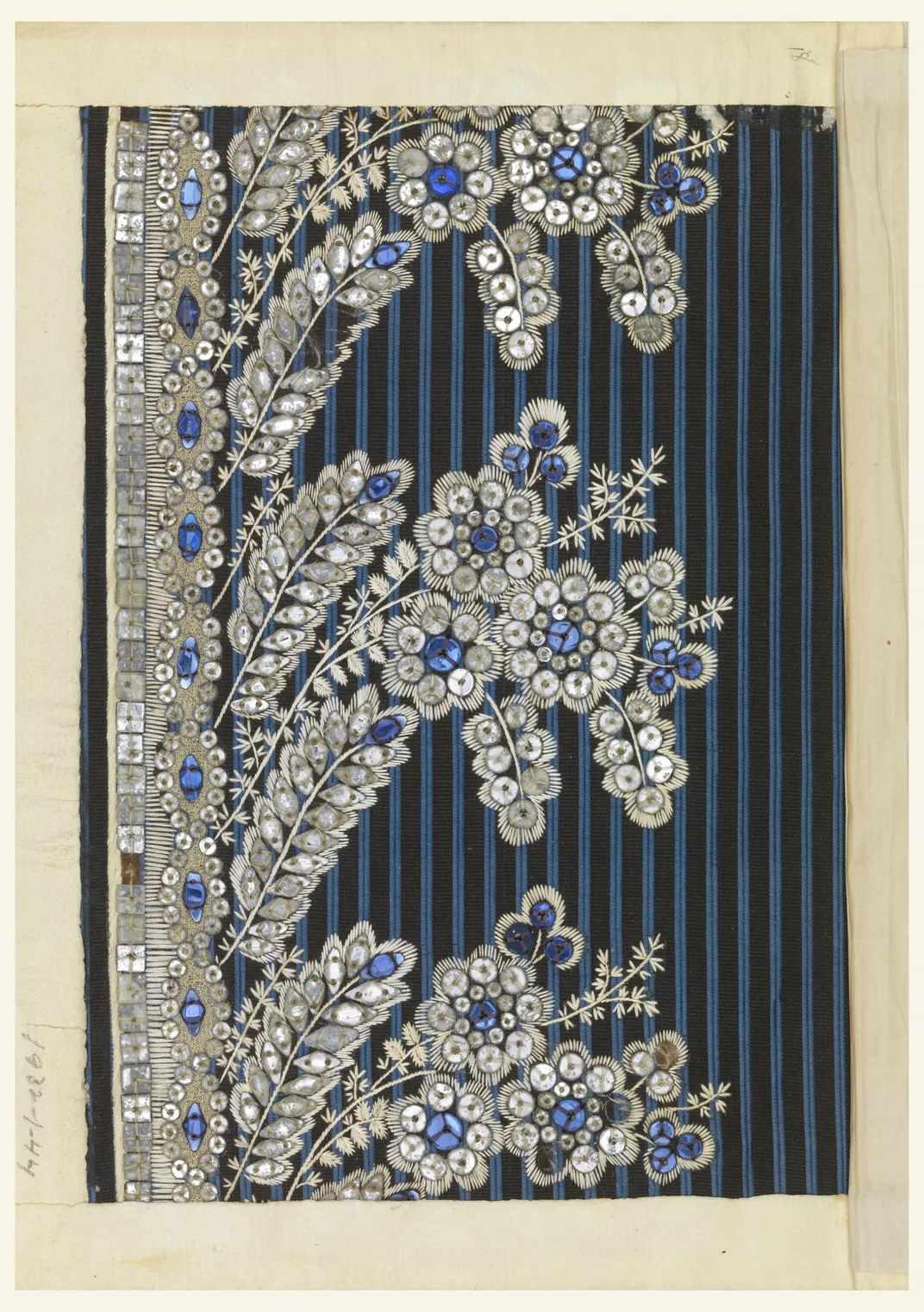 A floral pattern embroidered with white silk and pieces of blue and clear glass