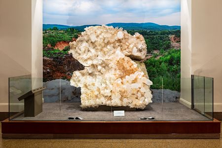 Museum display of the Berns Quartz from the front. The specimen is behind counter-height glass with a backdrop of Arkansas' Ouachita Mountains.
