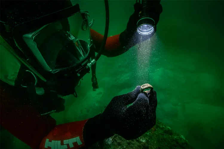 An underwater archaeologist examines a bronze signet ring discovered off the coast of Alexandria, Egypt.