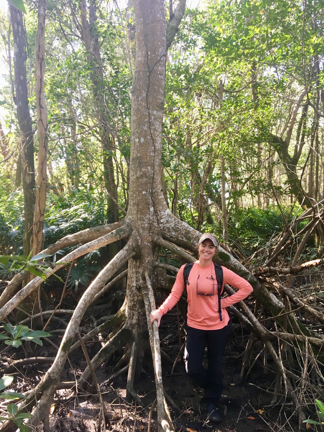 A person in front of a mangrove tree.