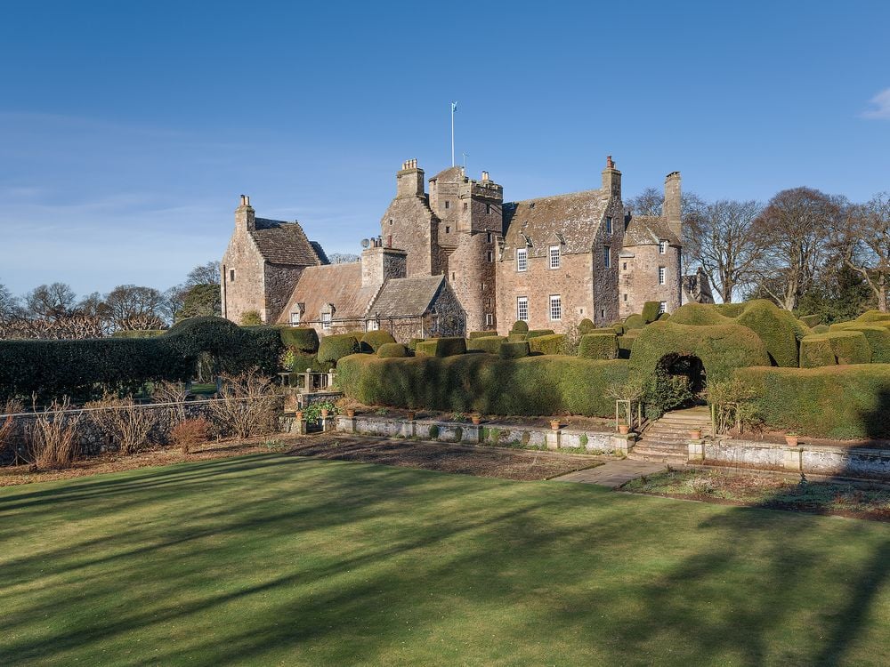 Large Gray stone castle overlooking vast green landscape