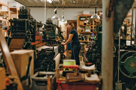 In the weave room, a worker uses a classic Crompton &amp; Knowles loom to make suitable fabric for some 18th-century furniture.
