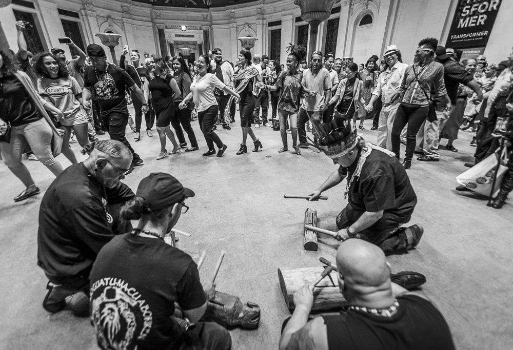 During the reception that closed the program “Taíno: A Symposium in Dialogue with the Movement,” presenters and audience members formed an areíto, or ancestral group dance, to celebrate community, resilience, and regeneration. 
El programa “Taíno: Un simposio en diálogo con el movimiento” se cerró con una recepción durante la cual los presentadores y el público formaron un areíto, o baile ancestral en grupo, para celebrar la comunidad y su capacidad para resistir y regenerarse.