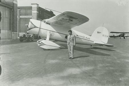 Aviator Wiley Post under the wing of the Winnie Mae (1933). 