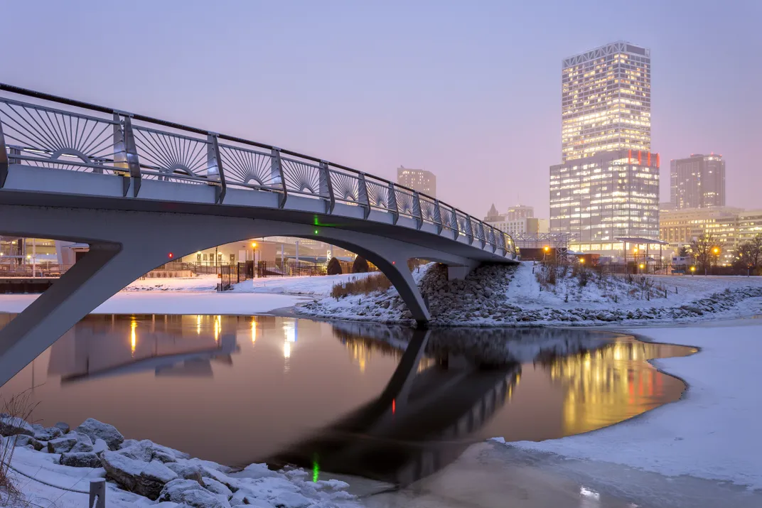 An image of Lakeshore State Park's bridge overlooking the skyline of Milwaukee, WI
