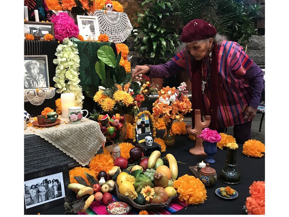 Doña Ofelia Esparza decorates the ofrenda