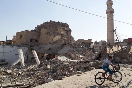 A bicyclist rides by the destroyed old mosque and tomb of  Nabi Jerjis, also known as Saint George, in central Mosul in July 2014.