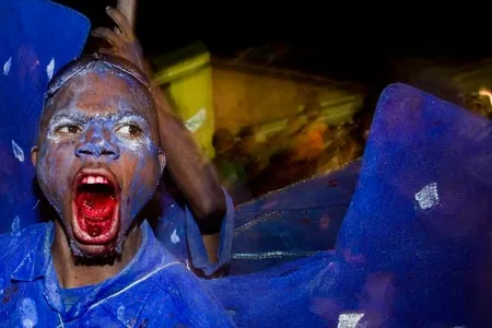Partaking in an old but ambiguous rite, blue "devils" (in Paramin, with mouths colored by dyed bubble gum) offer spectators a deal: pay, or get rubbed with body paint.