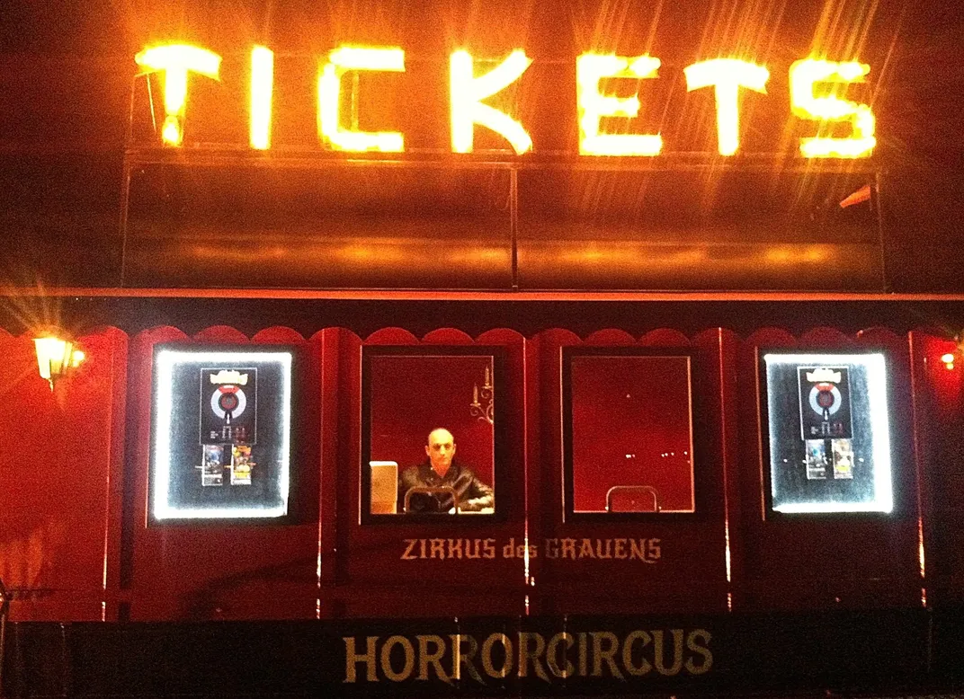 A man sells tickets to a horror-themed amusement park