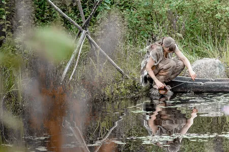 Participating in an archaeology experiment, a contemporary woman dons fur clothing similar to what Paleolithic people in colder climates might have worn.