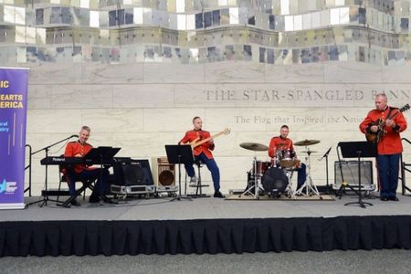 Four U.S. Marine band members perform on stage inside the museum