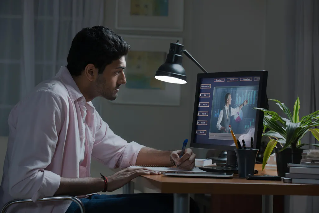 Stock photo image of a man watching a generic lecture on a desktop computer screen