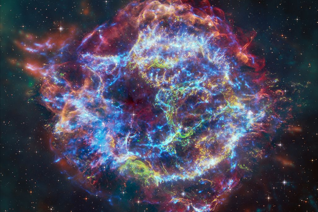 A colorful round cloud of gas and dust amid stars