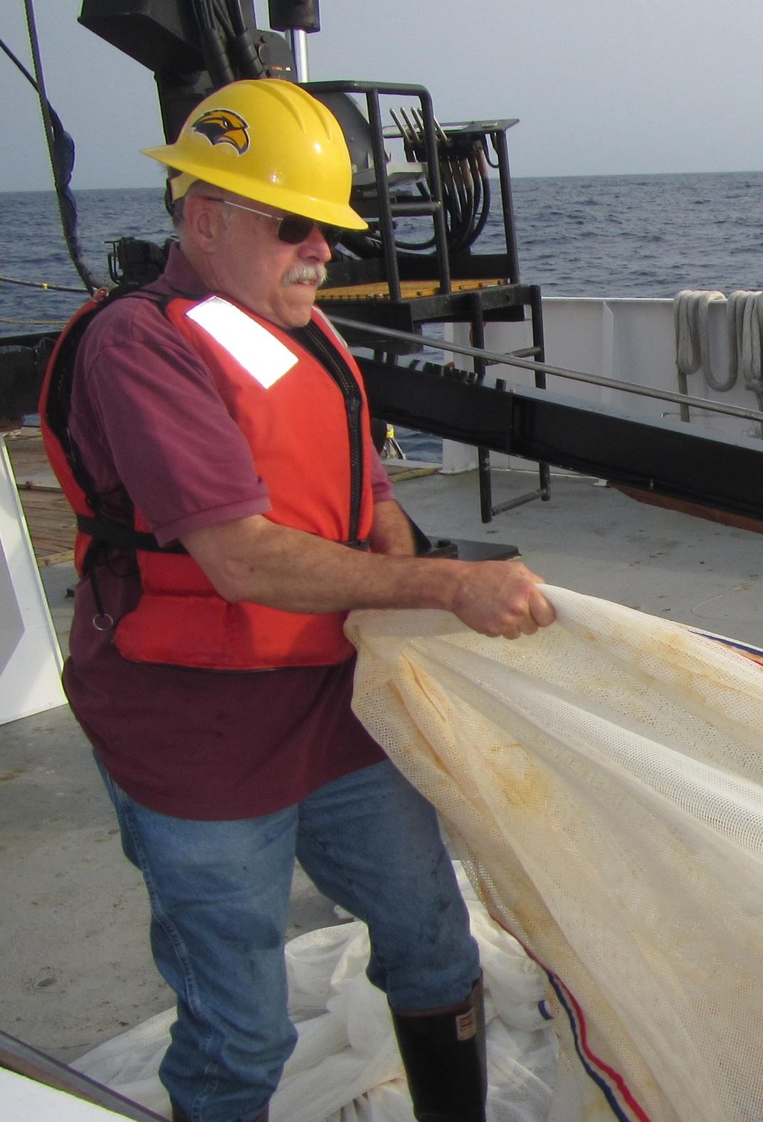 A man on a boat pulling a net.