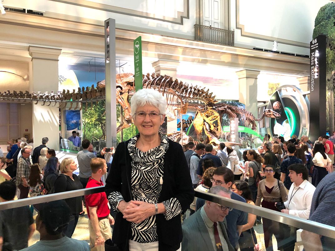 A group of people in a dinosaur exhibit.