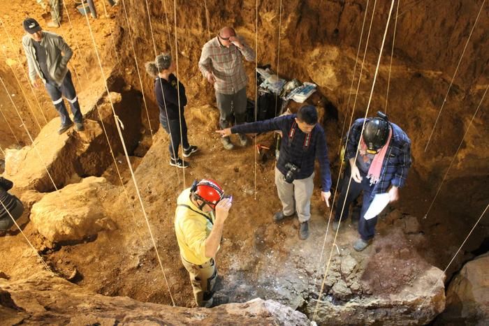 Aerial shot of people standing in a cave in Laos