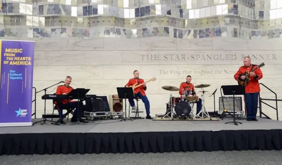Four U.S. Marine band members perform on stage inside the museum