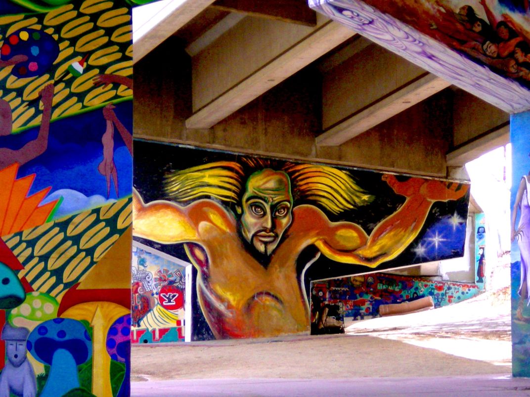 a colorful mural on a concret underpass