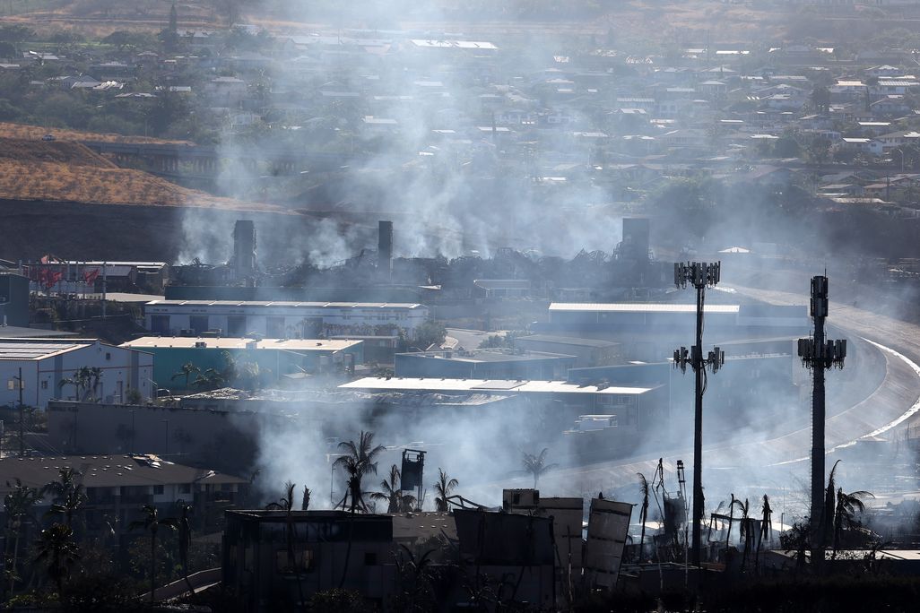 An aerial view of smoke rising from buildings burning from wildfires.