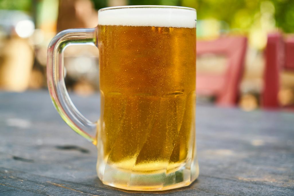 Mug of beer sitting on a table outside