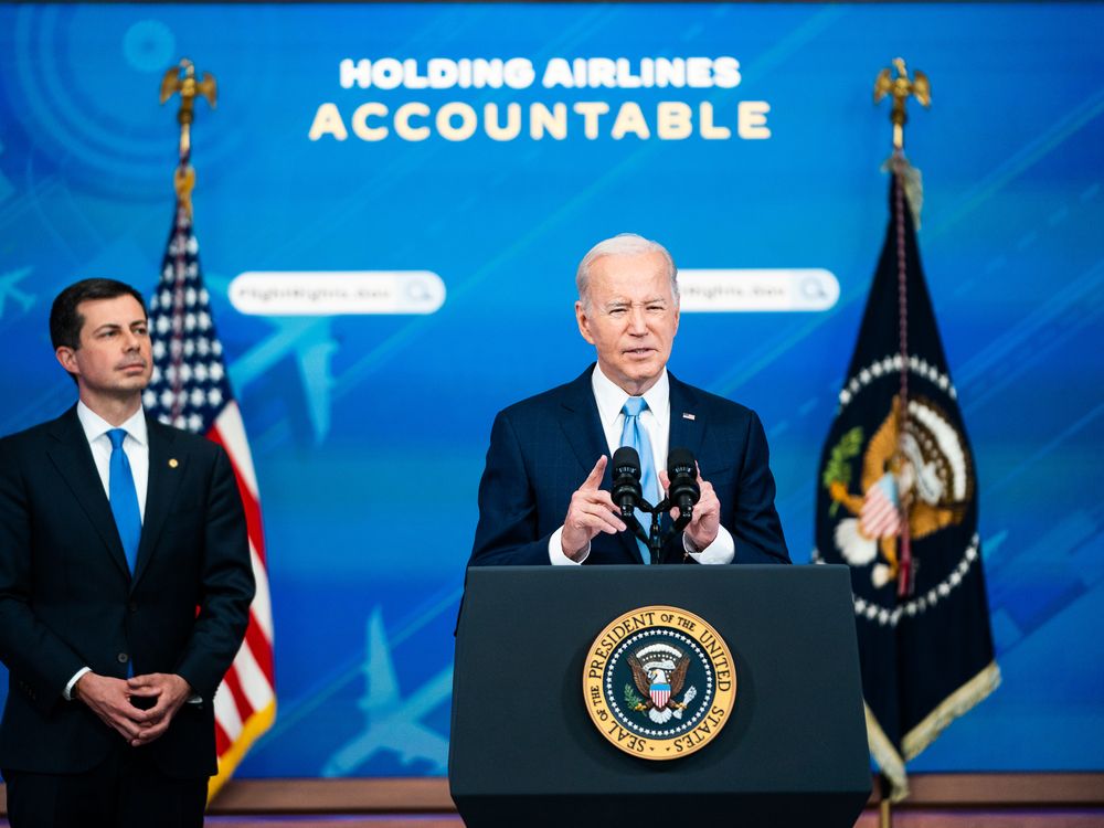 Transportation Secretary Pete Buttigieg listens as President Joe Biden delivers remarks