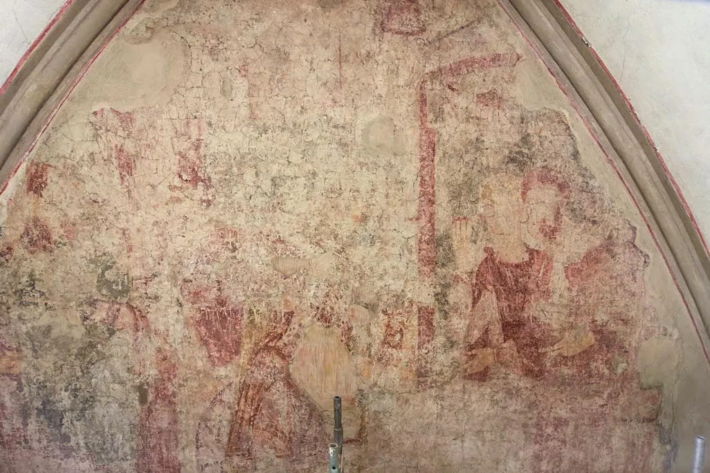 A very faded red and taupe frescoe with the outlines of some figures visible, enclosed in an arched dome